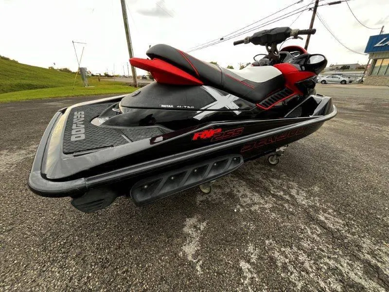 Slide: The Image of 2011 Sea-Doo RXP 255 jet ski, black and red, parked on asphalt. - 32