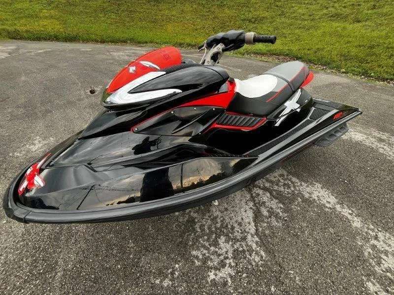 Slide: The Image of 2011 Sea-Doo RXP 255 jet ski, black and red, parked on pavement. - 6