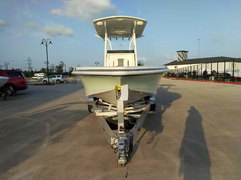Slide: The Image of 2024 Ranger 2510 Bay boat on trailer in parking lot, sunny day. - 2
