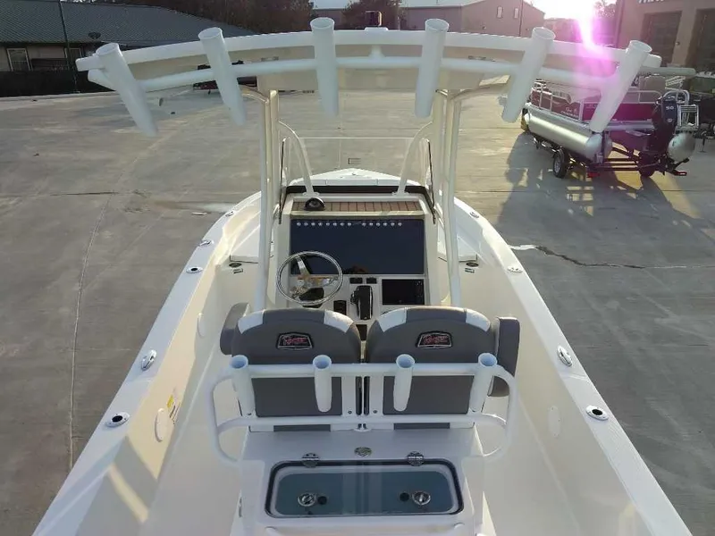Slide: The Image of 2024 Ranger 2510 Bay boat with dual seats and steering console, parked outdoors. - 4