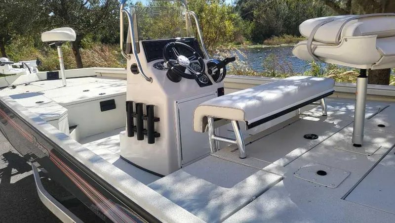 Slide: The Image of 2024 Ranger RB200 boat interior with seating and steering console near a lake. - 4