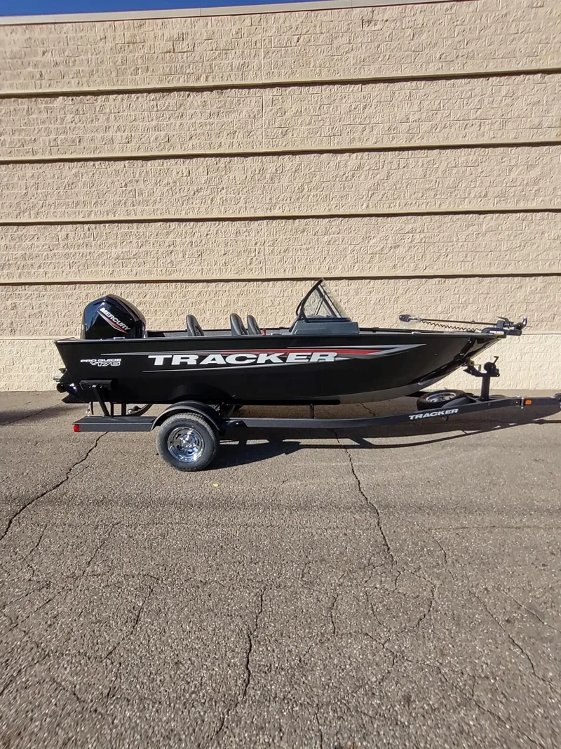 Slide: The Image of 2025 Tracker Pro Guide V-175 WT boat on trailer, parked outdoors. - 2