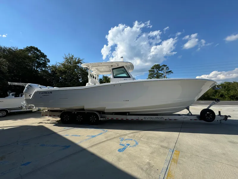 Slide: The Image of 2025 Caymas 401 CC boat on trailer under clear blue sky. - 12