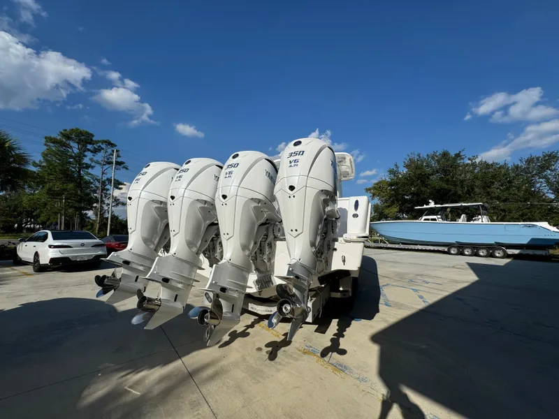 Slide: The Image of 2025 Caymas 401 CC boat with four powerful outboard engines in a sunny marina. - 16