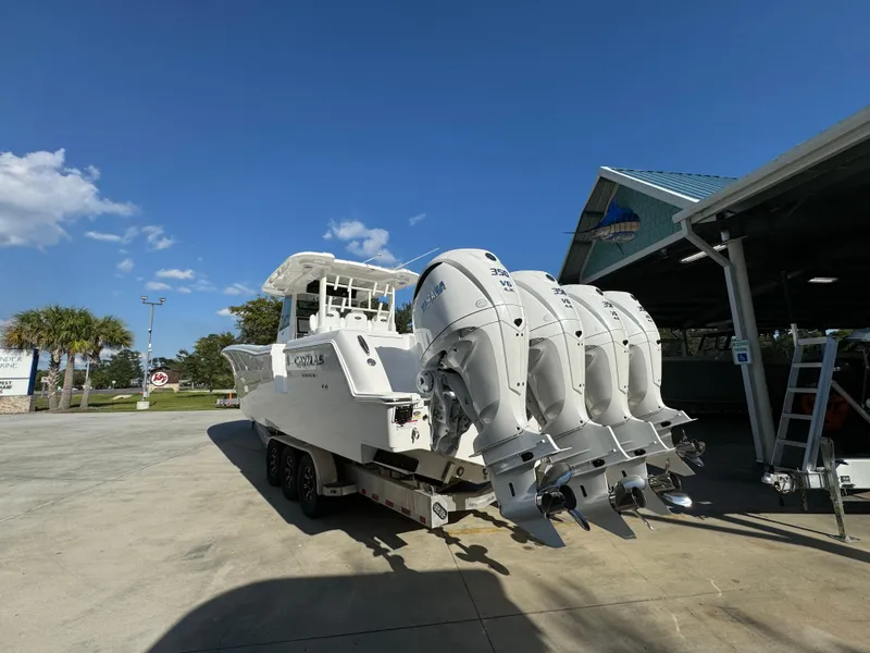 Slide: The Image of 2025 Caymas 401 CC boat with four powerful outboard engines, parked outdoors. - 18