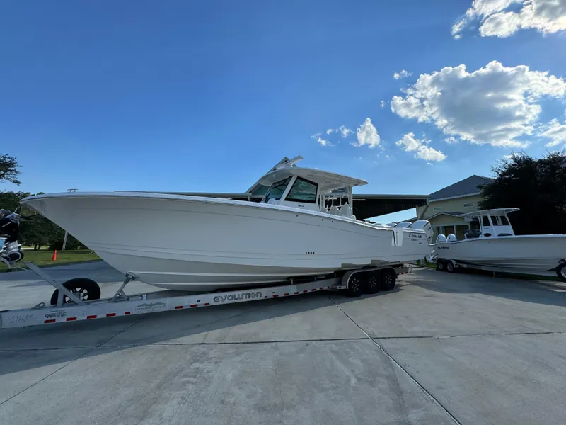 Slide: The Image of 2025 Caymas 401 CC boat on trailer under blue sky. - 3