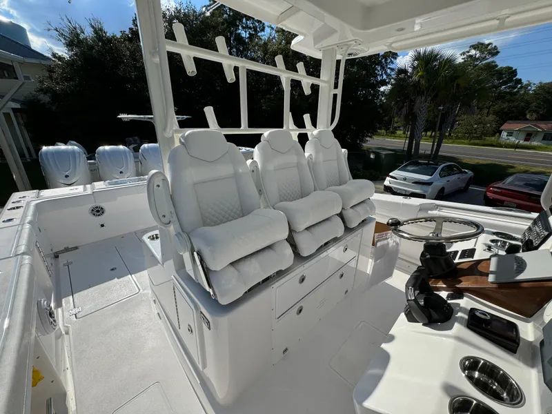 Slide: The Image of 2025 Caymas 401 CC boat interior with white cushioned seats and steering console. - 32