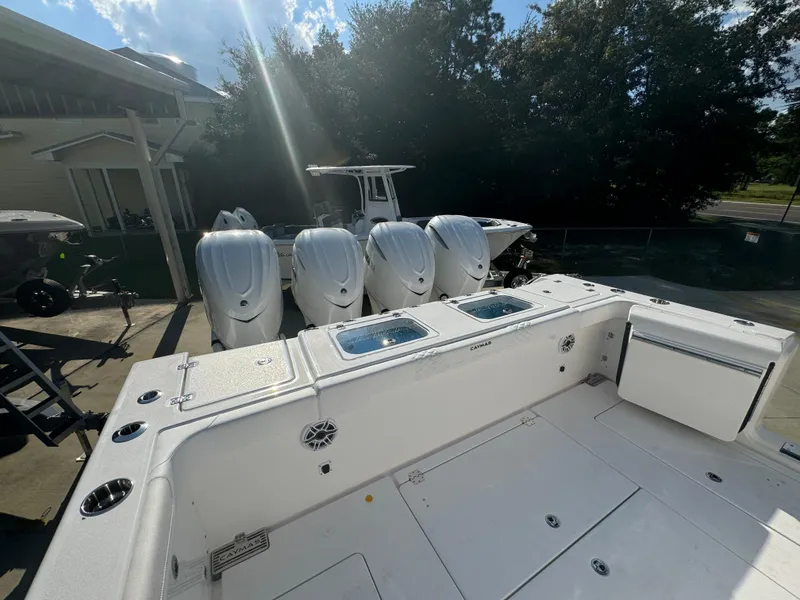 Slide: The Image of 2025 Caymas 401 CC boat with four powerful outboard engines, docked outdoors. - 39