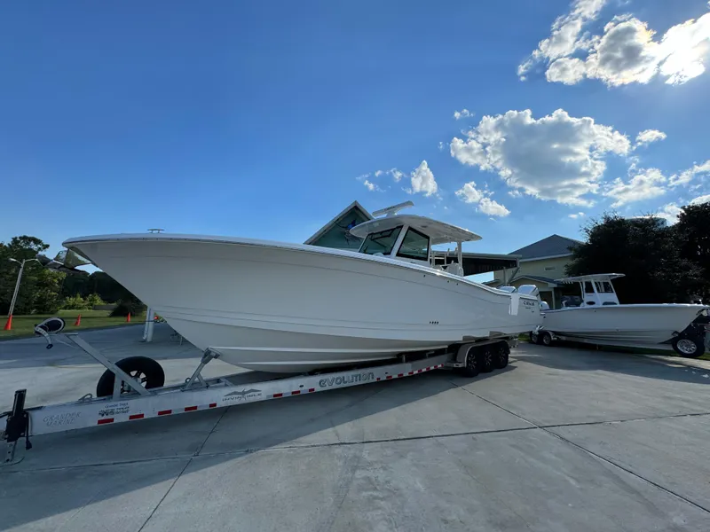 Slide: The Image of 2025 Caymas 401 CC boat on trailer under clear blue sky. - 4