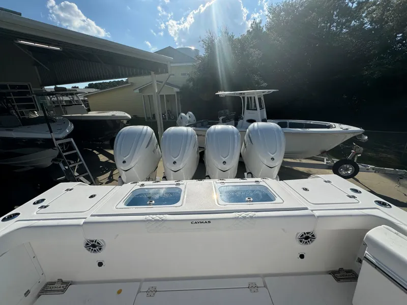 Slide: The Image of 2025 Caymas 401 CC boat with four powerful outboard engines in a sunny marina. - 40