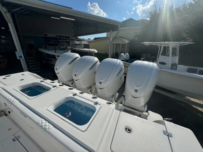 Slide: The Image of 2025 Caymas 401 CC boat with four powerful outboard engines in a sunny marina. - 41