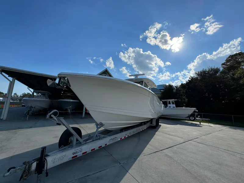 Slide: The Image of 2025 Caymas 401 CC boat on trailer under clear blue sky. - 6