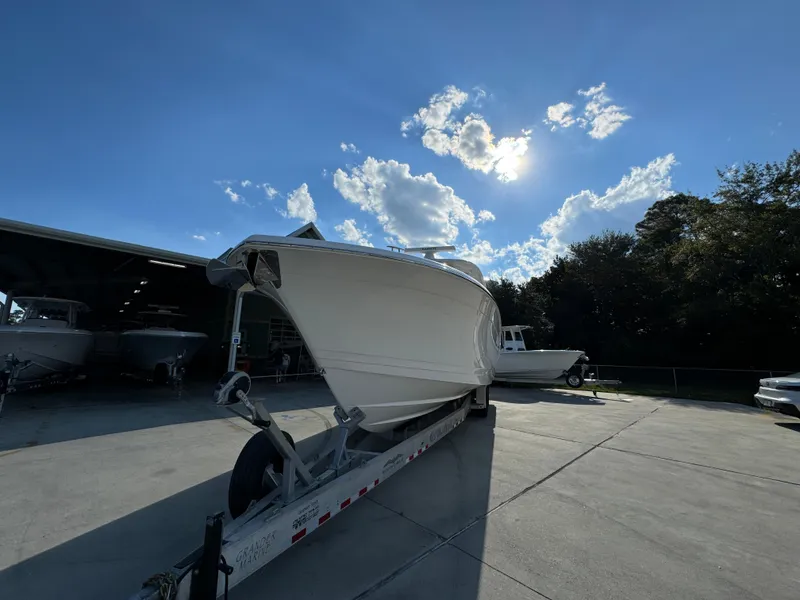 Slide: The Image of 2025 Caymas 401 CC boat on trailer under a bright blue sky. - 7