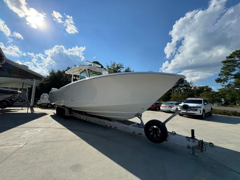 Slide: The Image of 2025 Caymas 401 CC boat on trailer under a sunny sky. - 9