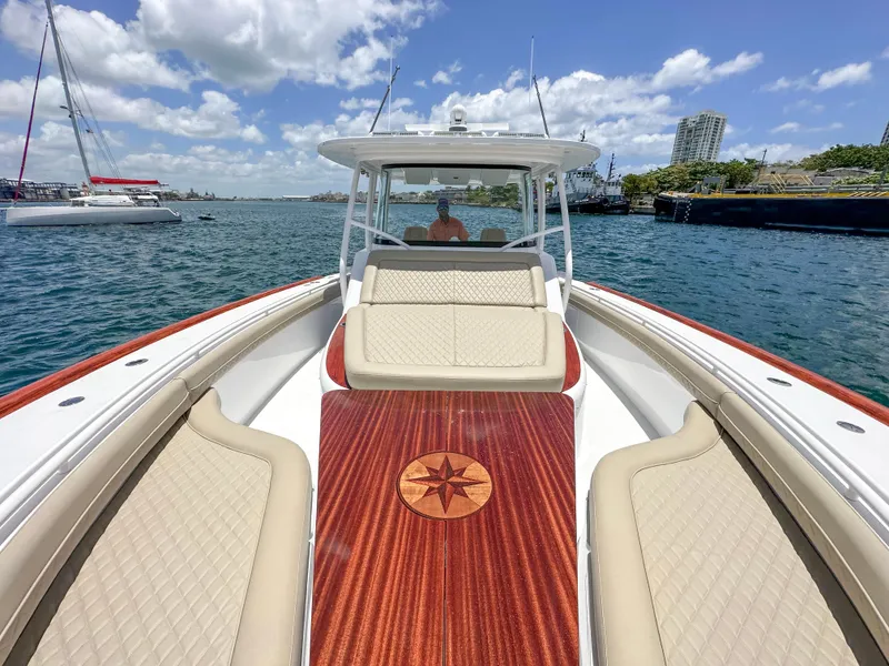 Slide: The Image of 2025 Vicem CC boat with elegant seating and wooden deck, cruising on a sunny day. - 4