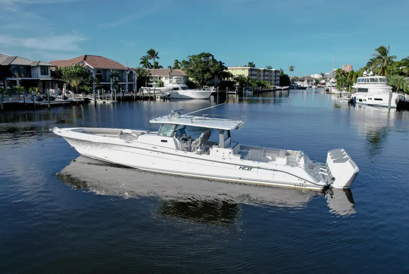 Slide: The Image of 2023 HCB 53 Sueños boat on a calm canal, surrounded by waterfront homes. - 0