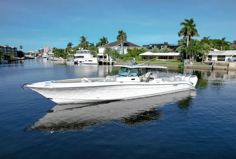 Slide: The Image of HCB 53 Sueños 2023 luxury boat on a calm waterway, surrounded by palm trees. - 1