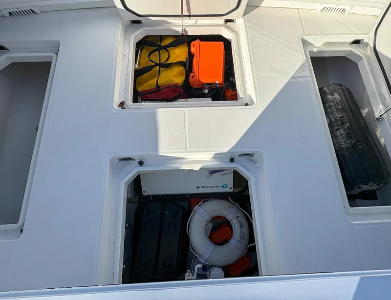 Slide: The Image of Storage compartments on 2023 HCB 53 Sueños boat with safety equipment. - 10