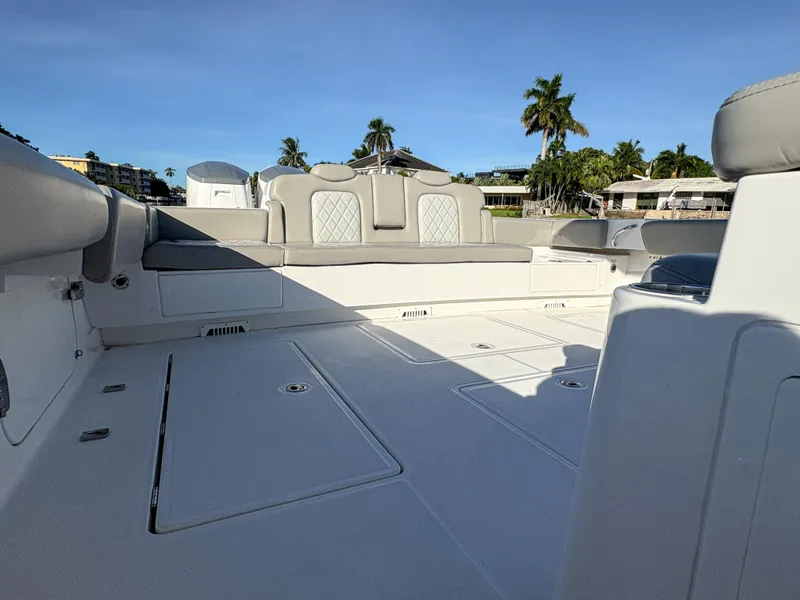 Slide: The Image of 2023 HCB 53 Sueños boat deck with luxurious seating and palm trees in the background. - 11