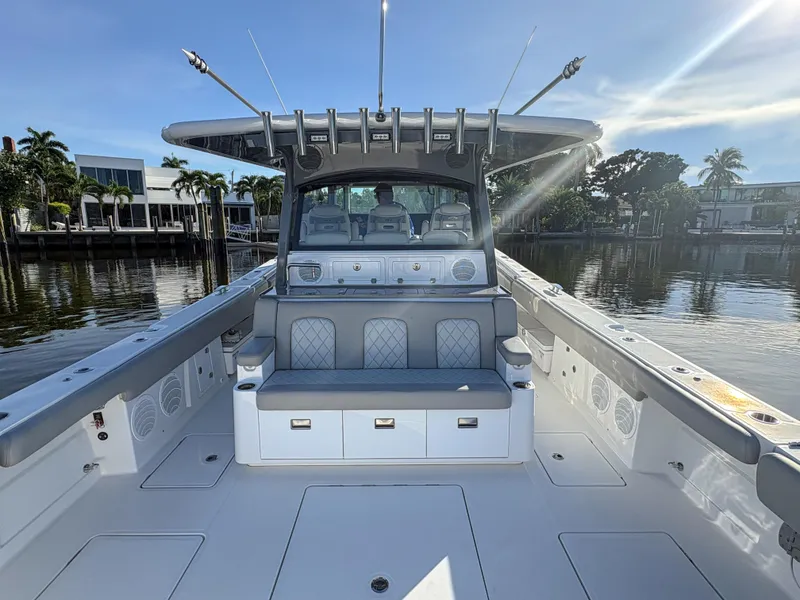 Slide: The Image of 2023 HCB 53 Sueños boat interior with seating and storage, docked by waterfront homes. - 12