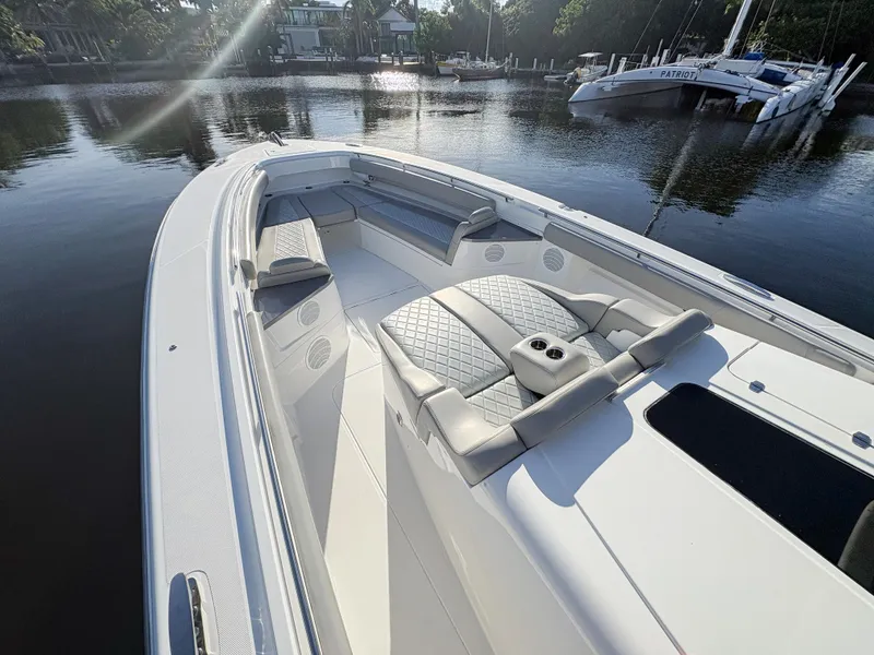 Slide: The Image of 2023 HCB 53 Sueños luxury boat with spacious seating, docked in a serene marina. - 34