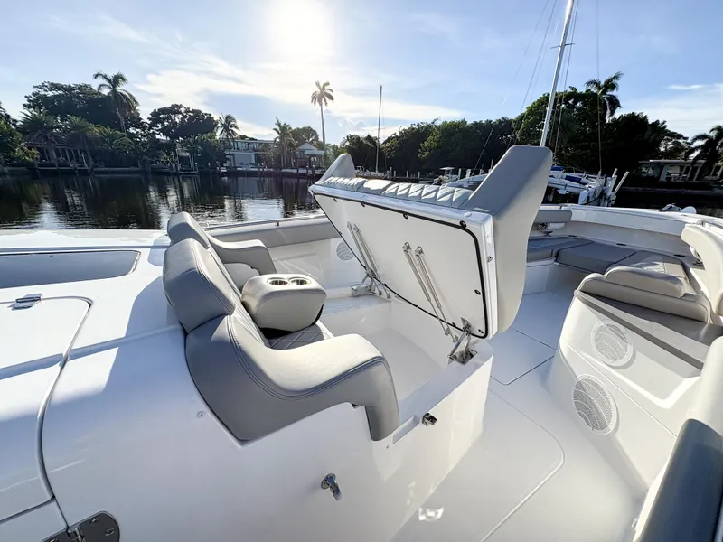 Slide: The Image of 2023 HCB 53 Sueños boat interior with seating and storage, docked by a scenic waterfront. - 40