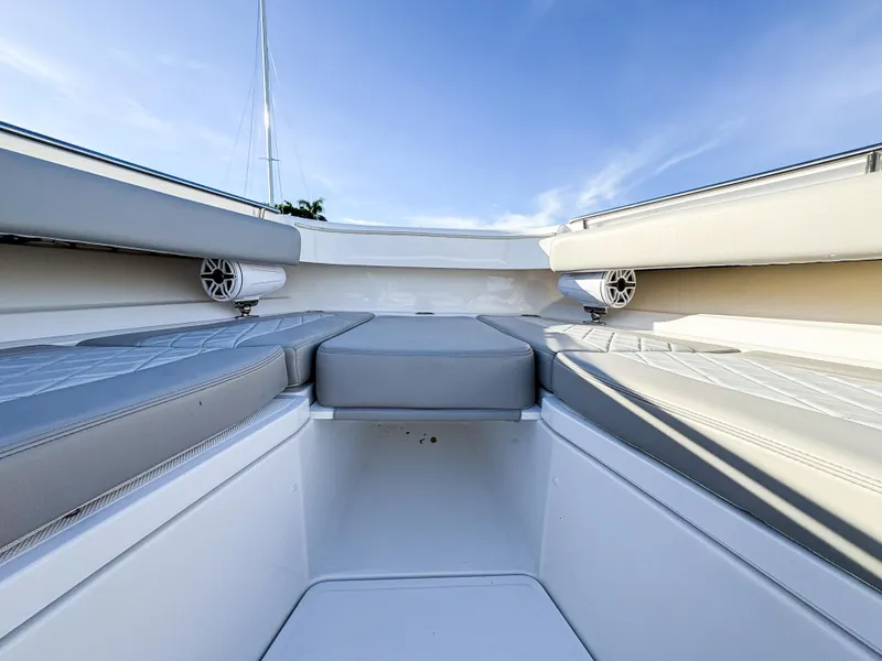 Slide: The Image of 2023 HCB 53 Sueños boat interior with cushioned seating and speakers under a clear sky. - 41