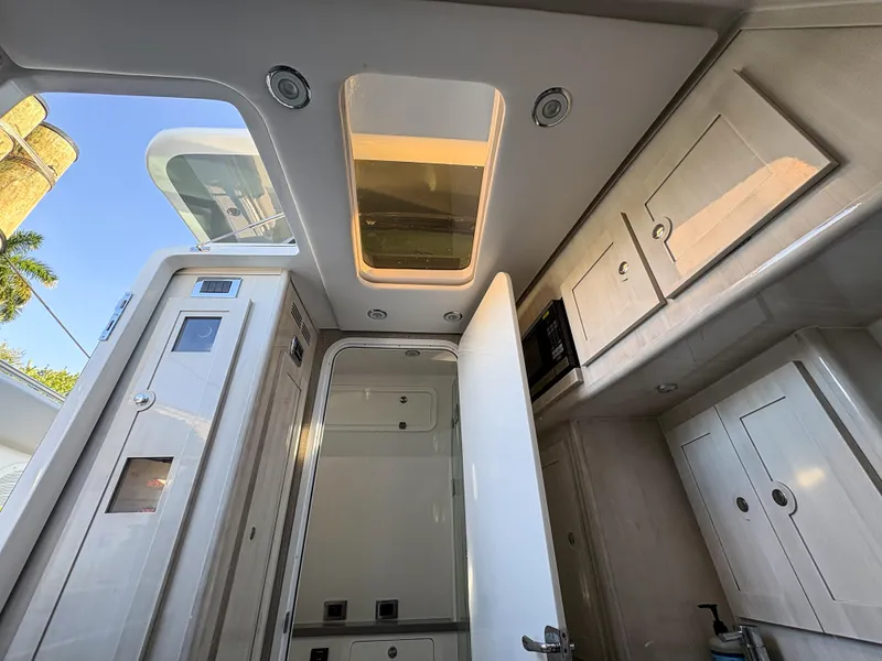 Slide: The Image of Interior of 2023 HCB 53 Sueños boat, featuring modern cabinetry and skylight. - 47