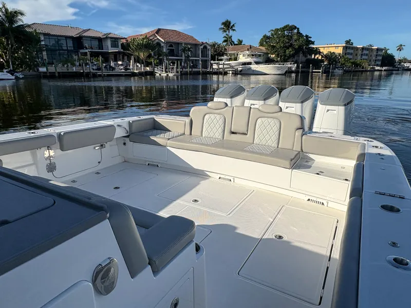 Slide: The Image of Luxury 2023 HCB 53 Sueños boat interior with spacious seating, docked by waterfront homes. - 5
