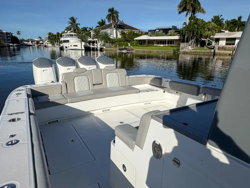 Slide: The Image of 2023 HCB 53 Sueños luxury boat with spacious seating, docked in a scenic waterfront area. - 7