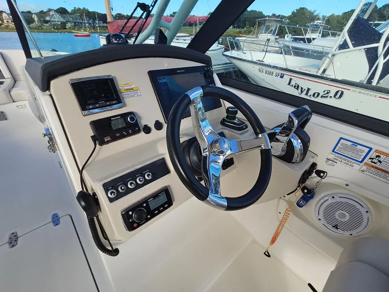 Slide: The Image of 2018 Boston Whaler 270 Vantage boat dashboard with steering wheel and controls. - 10