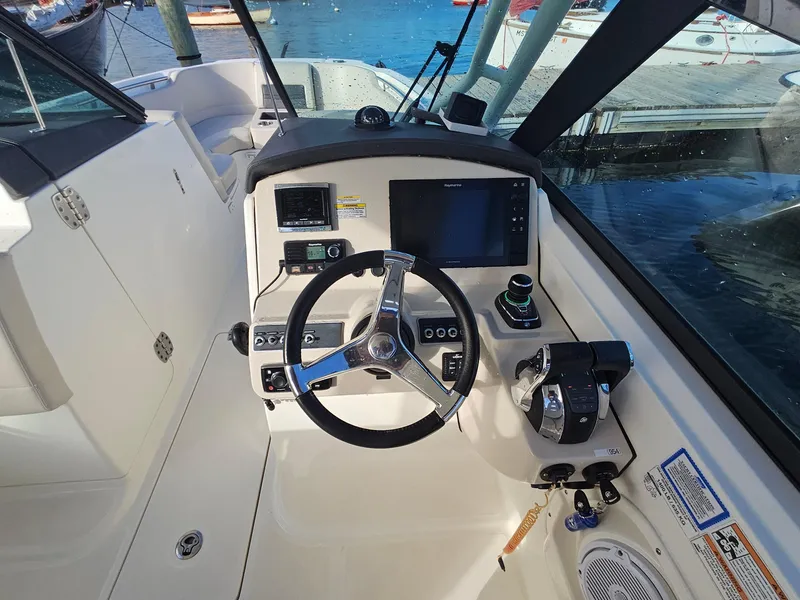 Slide: The Image of 2018 Boston Whaler 270 Vantage boat cockpit with steering wheel and control panel. - 11