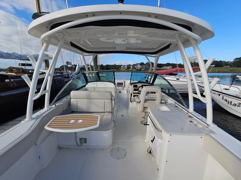 Slide: The Image of 2018 Boston Whaler 270 Vantage boat interior with seating and helm, docked at marina. - 18