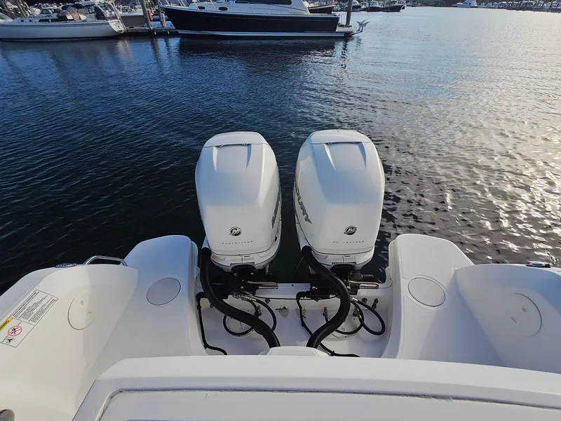 Slide: The Image of 2018 Boston Whaler 270 Vantage with twin outboard engines on calm water. - 21