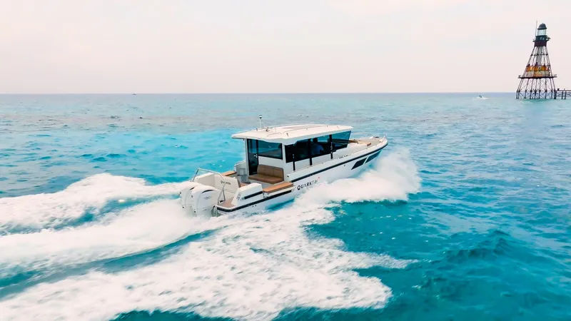 Slide: The Image of 2025 Quarken 35 Cabin cruising on blue ocean near a lighthouse. - 2
