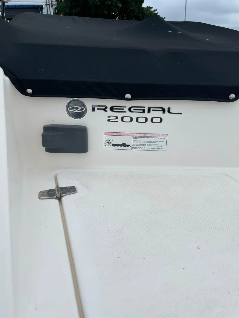 Slide: The Image of 2006 Regal 2000 Bowrider boat with black cover and logo. - 5