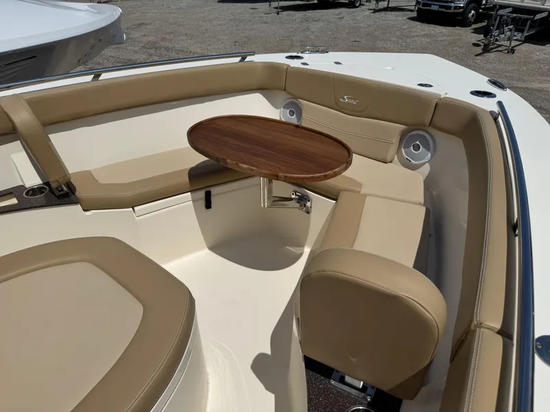 Slide: The Image of 2019 Scout 235 XSF boat interior with tan seating and a wooden table. - 16