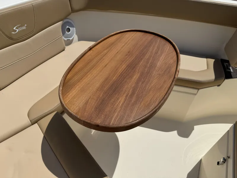 Slide: The Image of 2019 Scout 235 XSF boat interior with wooden table and beige seating. - 17