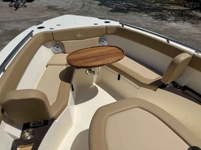 Slide: The Image of 2019 Scout 235 XSF boat interior with tan seating and wooden table. - 24