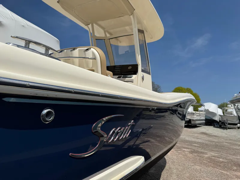 Slide: The Image of 2019 Scout 235 XSF boat with sleek design, docked under clear blue sky. - 3