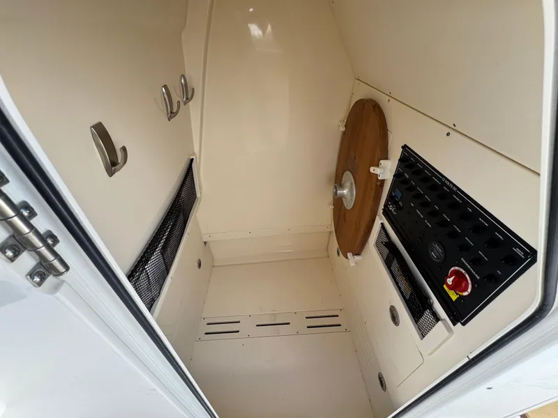 Slide: The Image of 2019 Scout 235 XSF boat interior storage compartment with hooks and control panel. - 35
