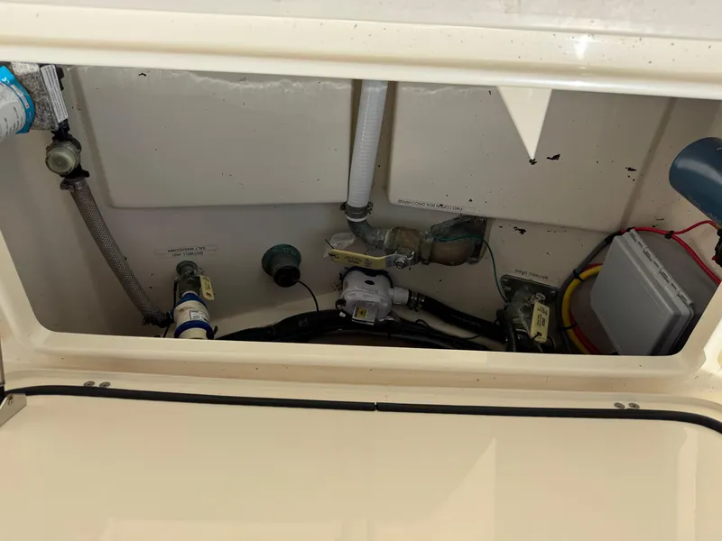 Slide: The Image of 2019 Scout 235 XSF boat interior compartment with visible plumbing and wiring. - 42