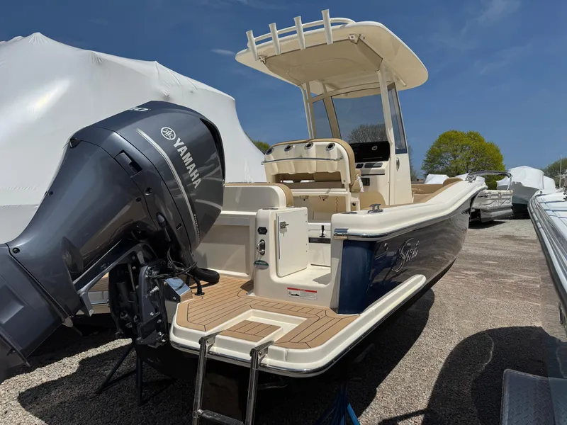 Slide: The Image of 2019 Scout 235 XSF boat with Yamaha outboard motor, parked outdoors. - 5