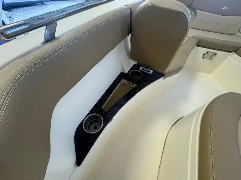 Slide: The Image of 2019 Scout 235 XSF boat interior with beige seating and cup holders. - 50