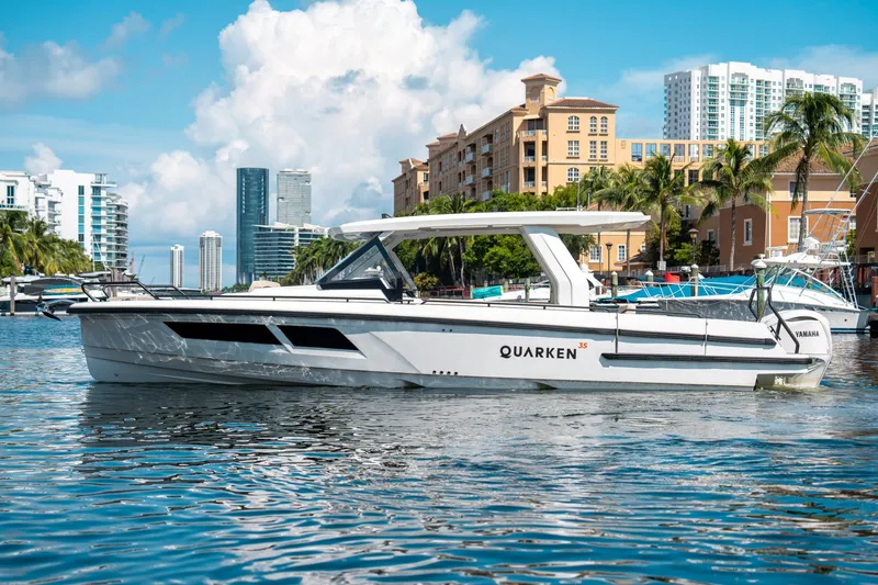 Slide: The Image of 2025 Quarken 35 Sport Tourer yacht cruising in a vibrant urban marina setting. - 5