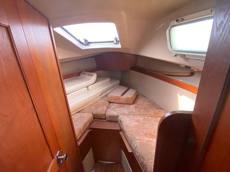 Slide: The Image of 1991 Newport 31 sailboat cabin with cozy bedding and wooden interior. - 10