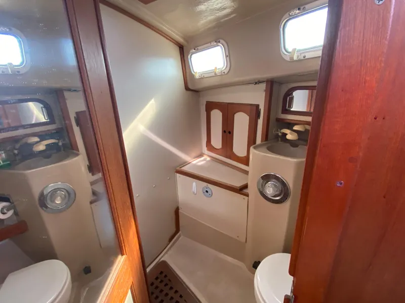 Slide: The Image of 1991 Newport 31 boat bathroom with wooden accents and compact fixtures. - 12