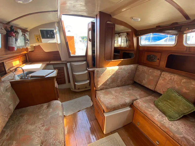 Slide: The Image of Cozy interior of a 1991 Newport 31 sailboat with wood finish and seating area. - 15