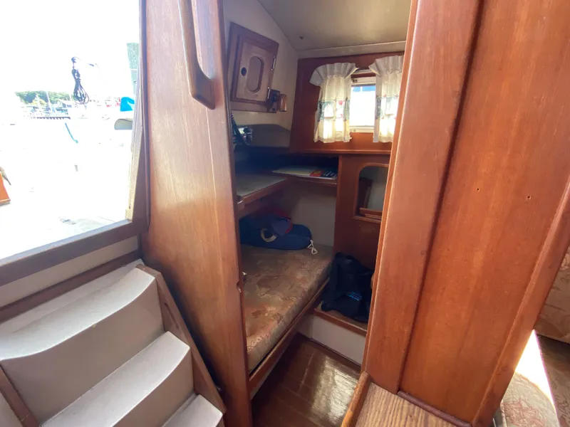 Slide: The Image of Cozy cabin interior of a 1991 Newport 31 sailboat with wooden furnishings and a small window. - 16
