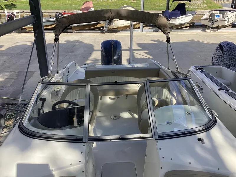 Slide: The Image of 2017 Stingray 234 LR boat with open cockpit and canopy in a marina. - 11